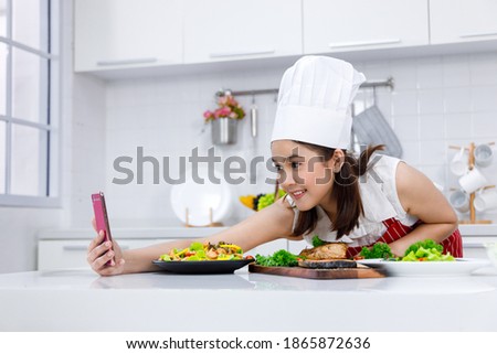 Woman chef selfie with salmon steak and salad she make in the kitchen. Concept woman preparing meals at home.