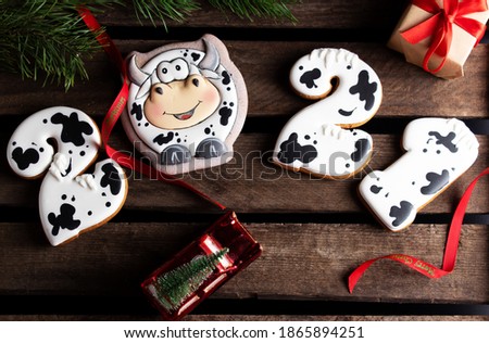 Gingerbread cookies in the form of numbers 2021, Gingerbread cow as symbol 2021 on wooden background. Christmas and Happy New Year 