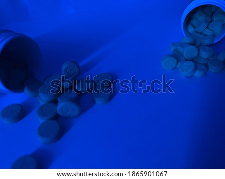 vitamin pills or drugs in the blue light room illustration and close up