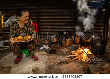 Vietnamese Woman at the fireplace in the kitchen