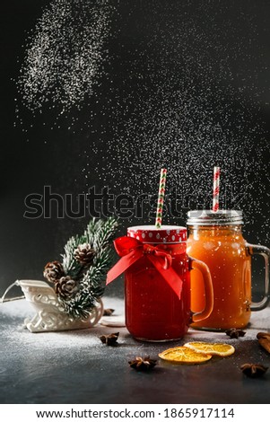 Beautiful Christmas picture with spicy drinks and imitation of snow made from powdered sugar. Winter hot drinks on a dark background with New Year's decor. Photo with imitation of film grain
