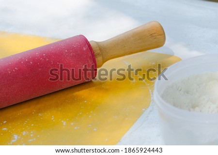Fuchsia rolling pin on a yellow pad