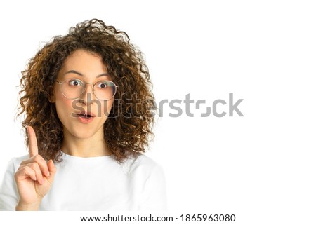 Curly Girl on a White Board Background Surprised Smiling Surprised Facial Expression Have an Idea Raised Index Finger Positive Mind Call to Action Space for Text Copy Space White Banner