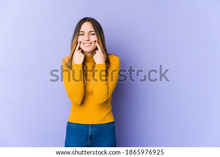 Young caucasian woman isolated on purple background doubting between two options.