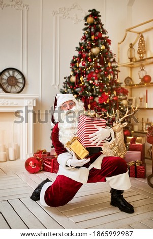 Happy Santa Claus brought many giftboxes to children.  New year and Merry Christmas holidays concept