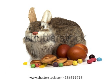 Happy Easter. Easter bunny, colored eggs with candy and pastries. Photo.