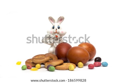 Happy Easter. Easter bunny, colored eggs with candy and pastries. Photo.