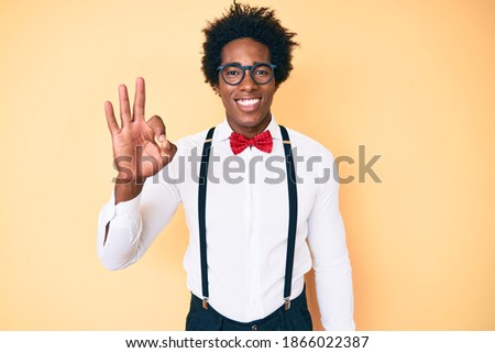 Handsome african american man with afro hair wearing hipster elegant look smiling positive doing ok sign with hand and fingers. successful expression. 