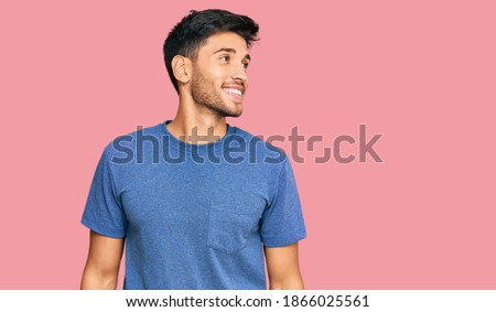 Young handsome man wearing casual clothes looking away to side with smile on face, natural expression. laughing confident.  Royalty-Free Stock Photo #1866025561
