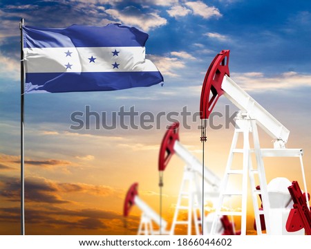 Oil rigs against the backdrop of the colorful sky and a flagpole with the flag of Honduras. The concept of oil production, minerals, development of new deposits.