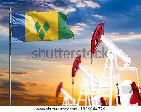 Oil rigs against the backdrop of the colorful sky and a flagpole with the flag of Saint Vincent and the Grenadines. The concept of oil production, minerals, development of new deposits.