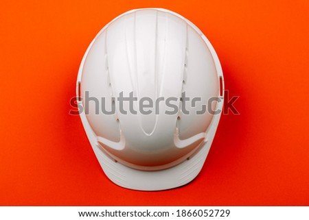 White engineering safety helmet on a red background. The view from the top.