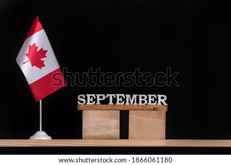 Wooden calendar of September with Canadian flag on black background. Autumn holidays in Canada.