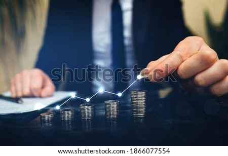 Businessman stacking coins with a graph of profit. Business successful  growth Royalty-Free Stock Photo #1866077554