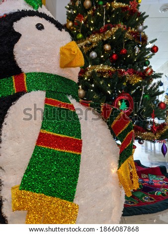Penguin decoration sits in front of Christmas tree