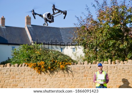 Close up of a surveillance drone in blue sky being operated by a surveyor