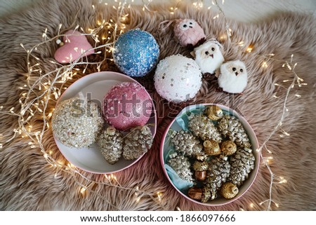 Beautiful Christmas tree baubles, toys and fairy lights on faux fur, above view
