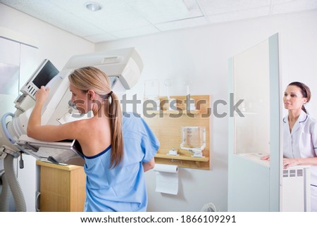 Patient undergoing a mammogram at x-ray machine