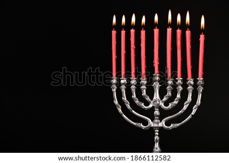 Silver menorah with burning candles on black background, space for text. Hanukkah celebration