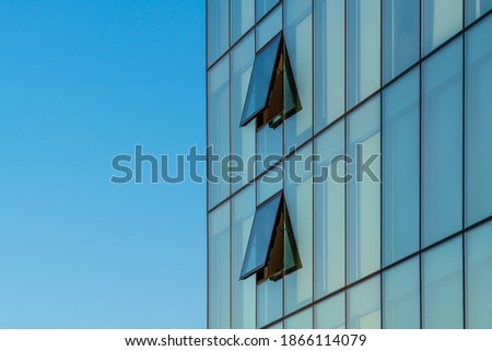 Glass facade with opened windows on a modern building 