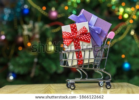 Grocery shopping cart with  wrapped holiday gift boxes inside.
Christmas family shopping concept