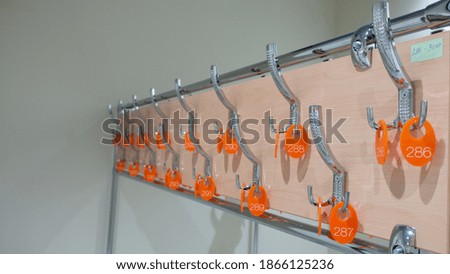 Hooks for clothes with numbers in the empty locker room.