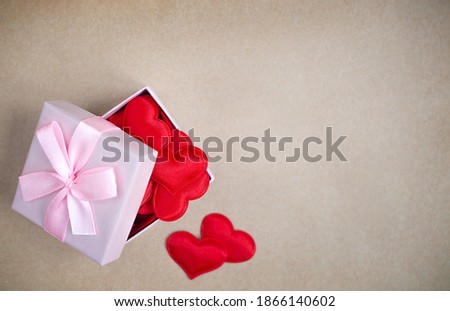 box with a gift red hearts on the craft background. Valentine's Day concept with copy space