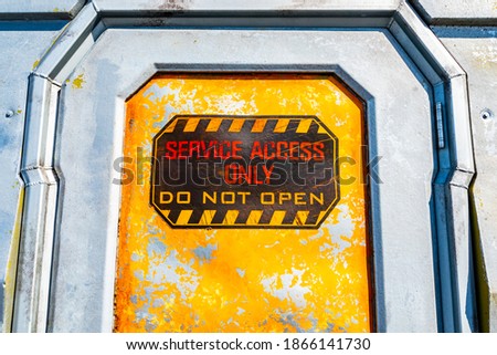 Service Access Only, Do Not Open sign on metal door. Warning against unauthorized personnel.