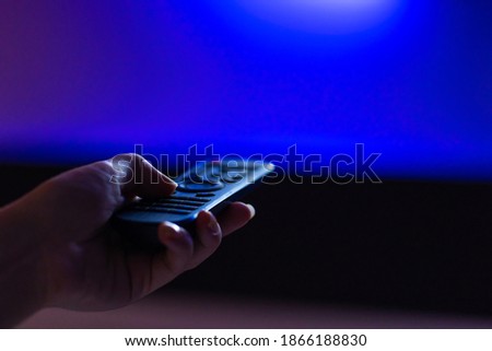 leisure at home. Watch TV. Remote control in hand close-up. Royalty-Free Stock Photo #1866188830