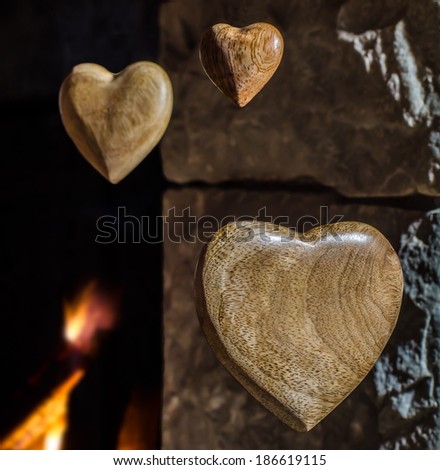 Wooden hearts floating by an old stone fireplace