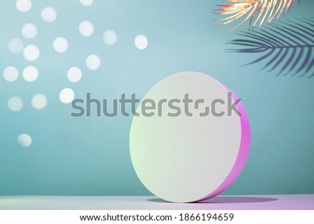 Round podium mockup in horizontal composition with golden palm leaves on a blue background with neon illumination, place for your text