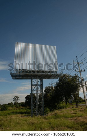 Blank billboard on the background of the road and blue sky.