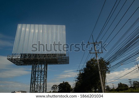 Blank billboard on the background of the road and blue sky.