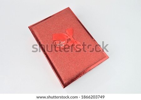 Red gift box with ribbon isolated on a white background.