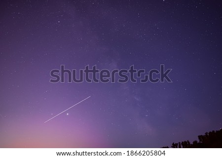 Milky Way and satellite in the night sky.