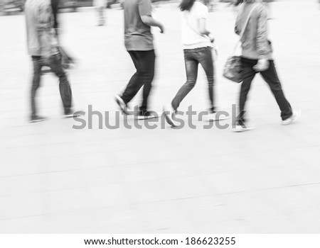 City business people walking in railway station square, black and white blur background