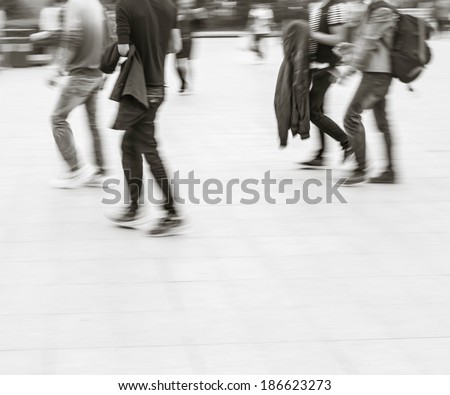 City business people walking in railway station square, black and white blur background