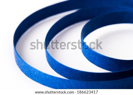 Curved blue paper ribbon isolated on on a white background. Macro lens closeup shot 1:1.