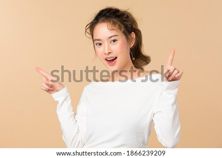 Portrait of young Asian woman smiling isolated on brown background
