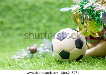 Soccer ball Christmas Holiday on green grass with ornaments
