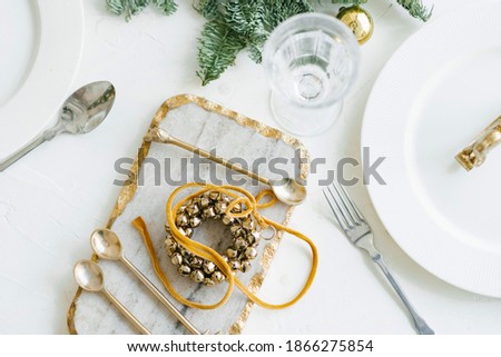 Christmas table setting. Classic decor with a wreath of Golden bells
