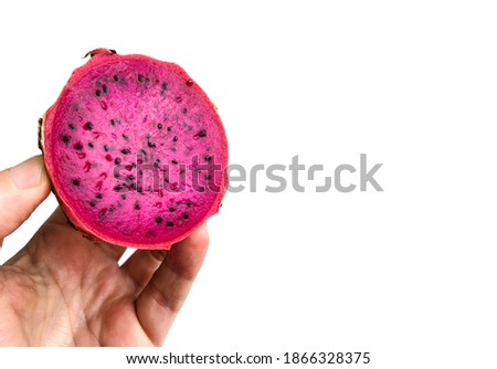 Male hand holding a Pitaya or Dragon Fruit cut in half. Inside view of the fruit with white background.