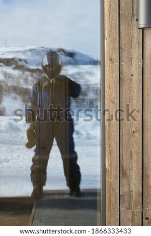 Tourists take pictures with the reflection of the glass door. With the background view is the mountain covered with snow                            