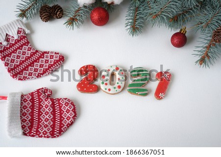 christmas decoration of red balls, knitted socks and 2021 on a white wooden background                               