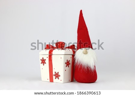Christmas gnome with a red gift box isolated on a white background.