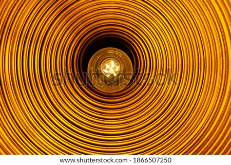 lightbulb in an orange lamp - concept photo