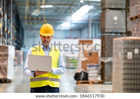 Warehouse manager with laptop entering inventory data to database Royalty-Free Stock Photo #1866517930