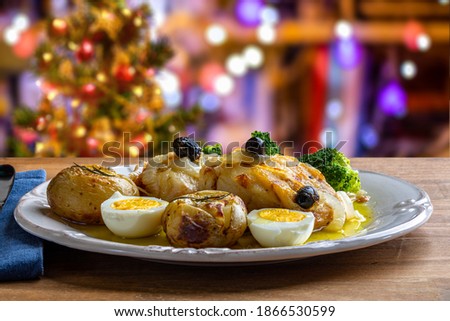 Cod loin baked in olive oil, with potatoes, broccoli, boiled egg and black olives. Typical dish of Portugal. Christmas decoration.