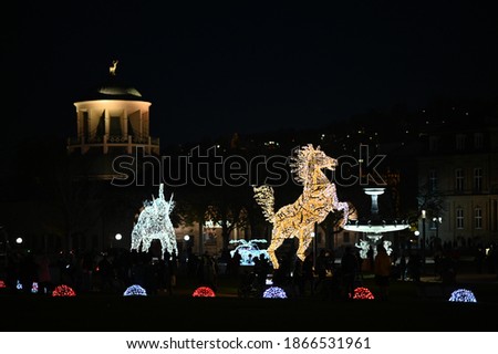 public Christmas decoration, light on statues of horse, elephant and sport car on the public palace square  Schlossplatz, Stuttgart, Germany
