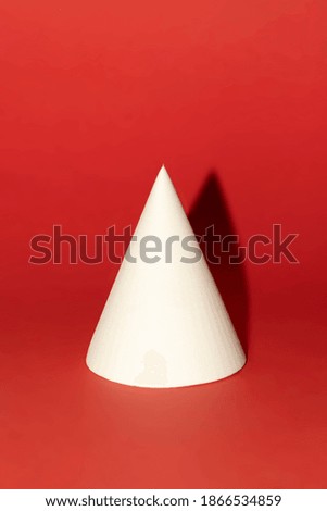 minimalist Christmas card white cone with shadow on a red background  